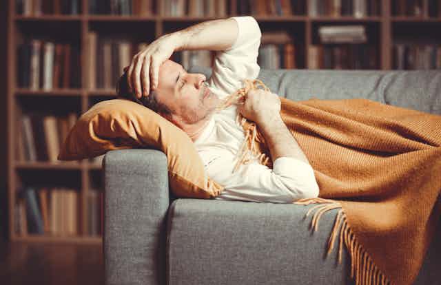 A man with a breakthrough infection lying on a couch