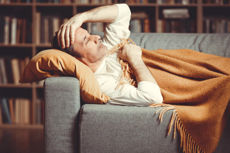 A man with a breakthrough infection lying on a couch