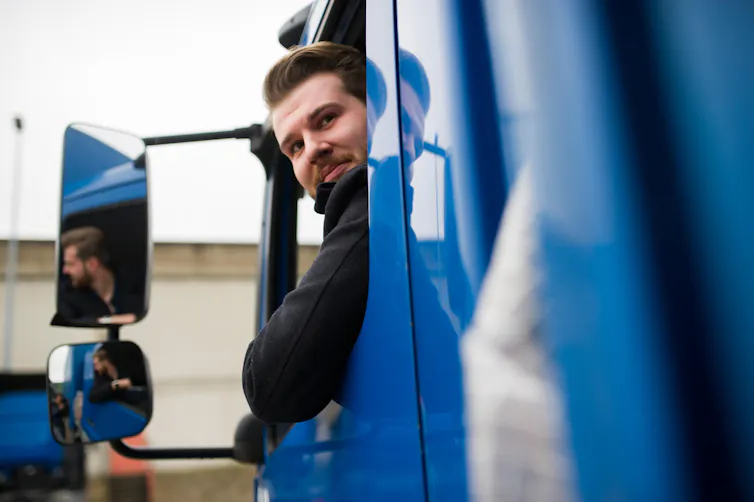 Lorry driver looking out of his window and reversing