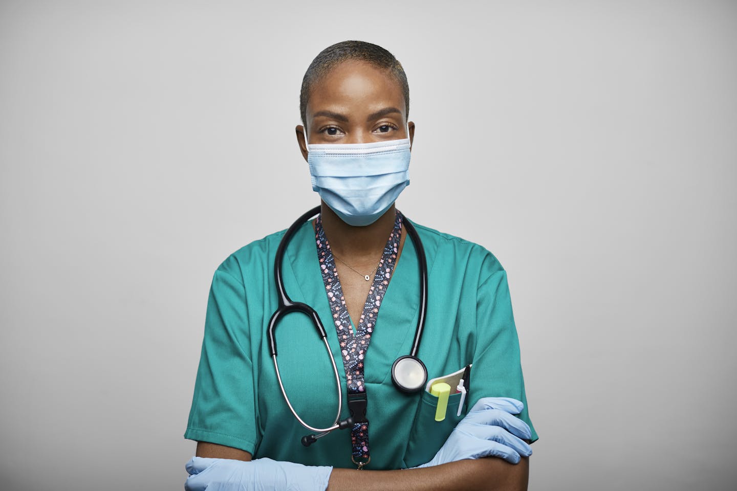 masked female health care worker looking straight at camera with arms crossed