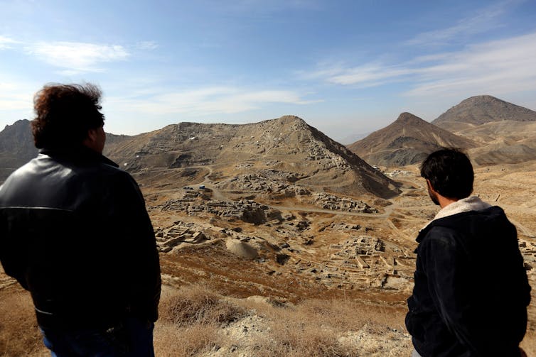 Two men look across the Men Aynak valley of Afghanistan