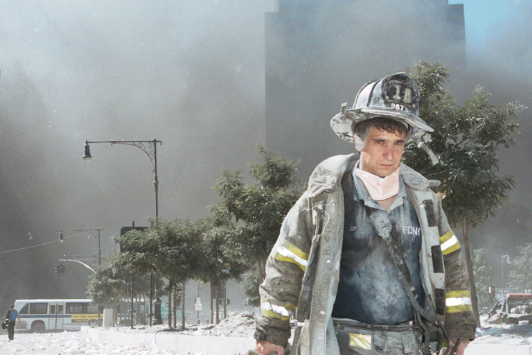 A New York City firefighter walks away from Ground Zero on 9/11
