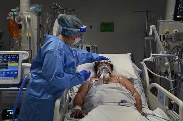 COVID patient in ICU with nurse attending