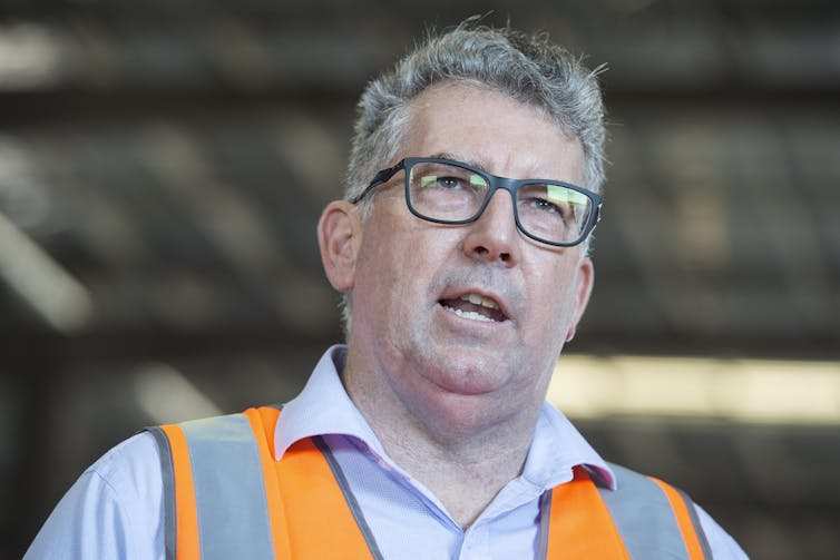 man in high-vis vest and blue shirt