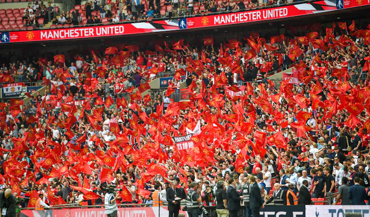 The red-clad crowd of Manchester United supporters at a Wembley stadium match