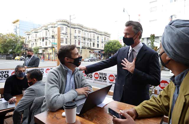 California Gov. Gavin Newsom in San Francisco at an outside table with volunteers on his anti-recall campaign.