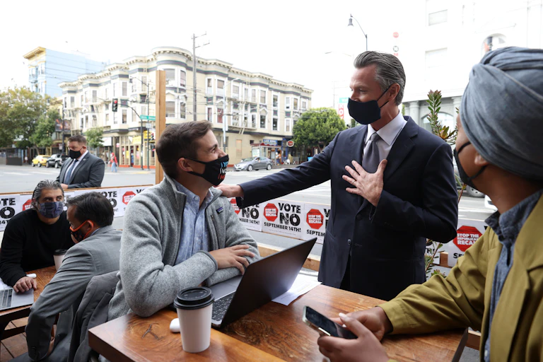 California Gov. Gavin Newsom in San Francisco at an outside table with volunteers on his anti-recall campaign.