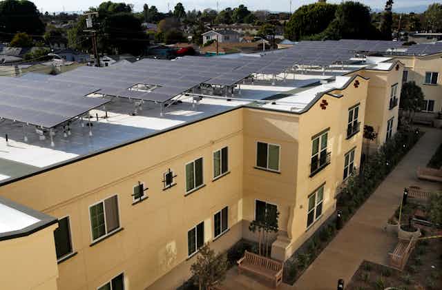 Apartment building with solar panels on roof.