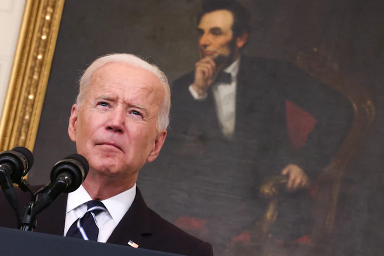 President Joe Biden addresses America in front of a portrait of Abraham Lincoln.