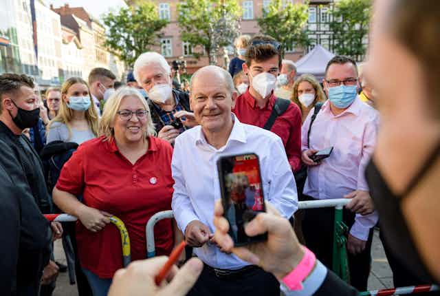 Olaf Scholz having his photo taken with a group of people at a campaign event. 