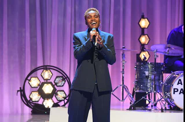 Singer in suit on stage.