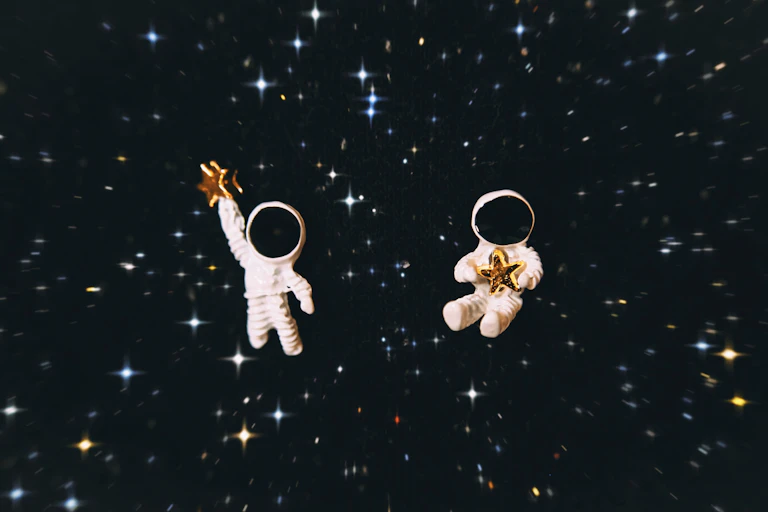 two astronaut figurines with a star background