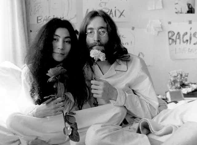 Yoko Ono and John Lennon pose with flowers in an early 1970s photograph