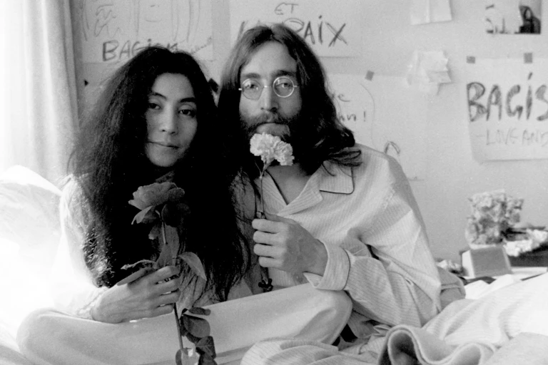 Yoko Ono and John Lennon pose with flowers in an early 1970s photograph