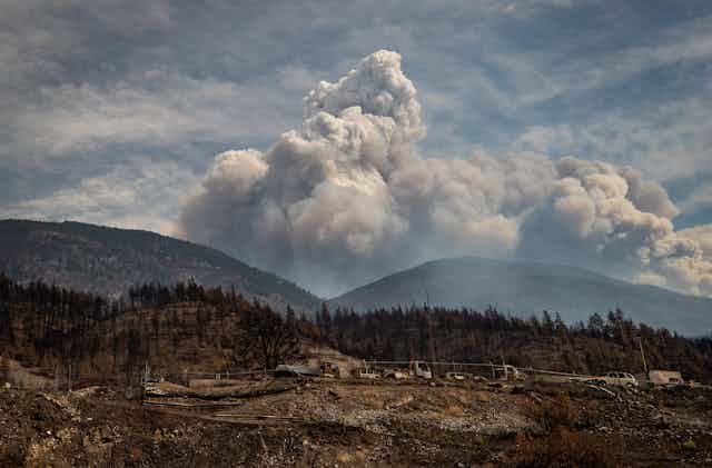 Fire clouds are seen behind a mountain after destroying a town