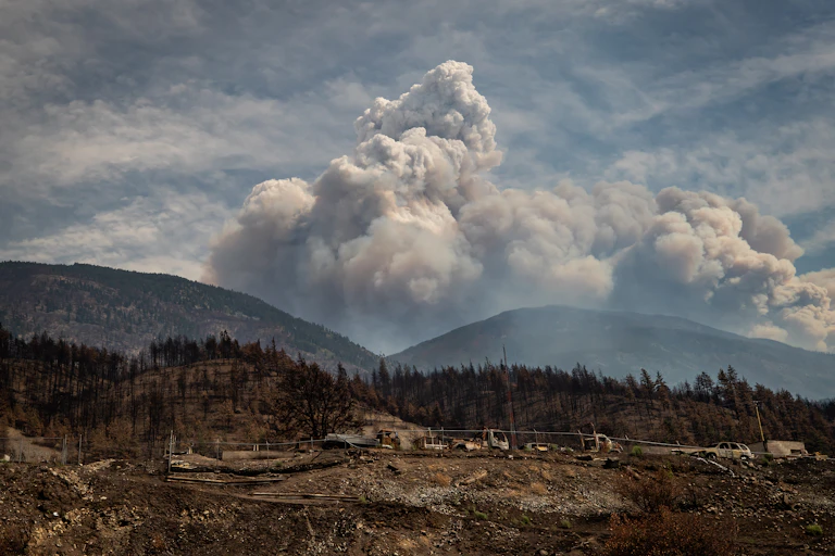 Fire clouds are seen behind a mountain after destroying a town