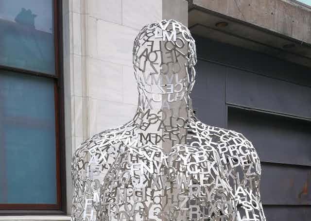 A sculpture of a human figure made of letters from the alphabet.
