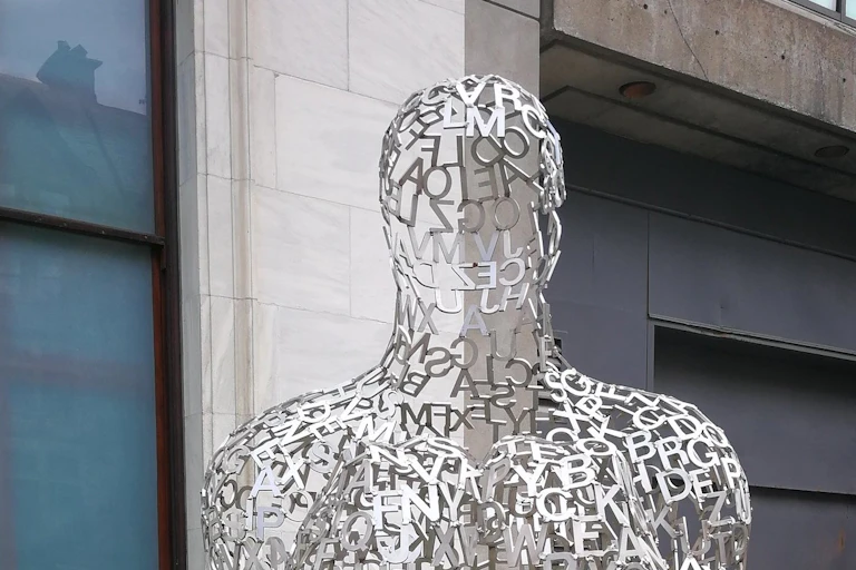 A sculpture of a human figure made of letters from the alphabet.