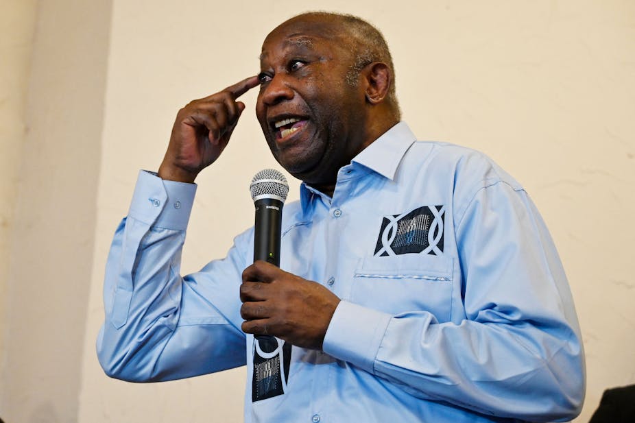 A man holding a microphone and gesticulating while speaking