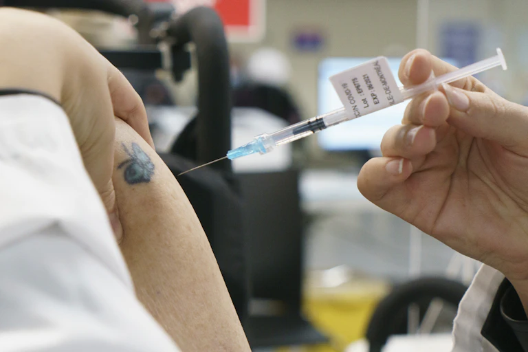 Introduction of a syringe in a tattooed arm