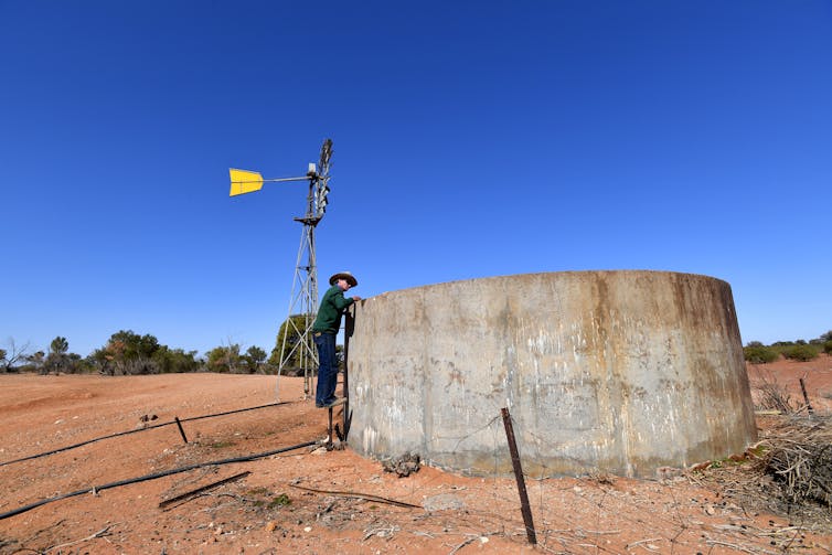 A farmer checks a water tank