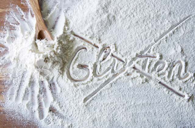 la palabra gluten escrita sobre harina y tachada