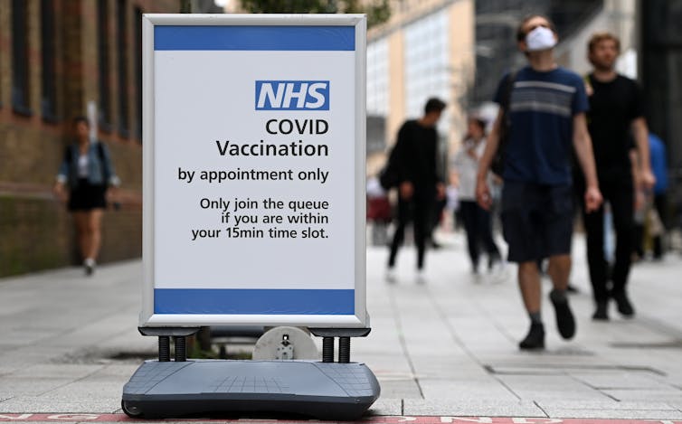 A street sign advertising an NHS Covid Vaccination site by appointment only.