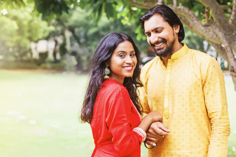Man and a woman smile in traditional Indian clothing