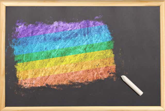 Pizarra con una bandera arcoíris pintada con tiza.