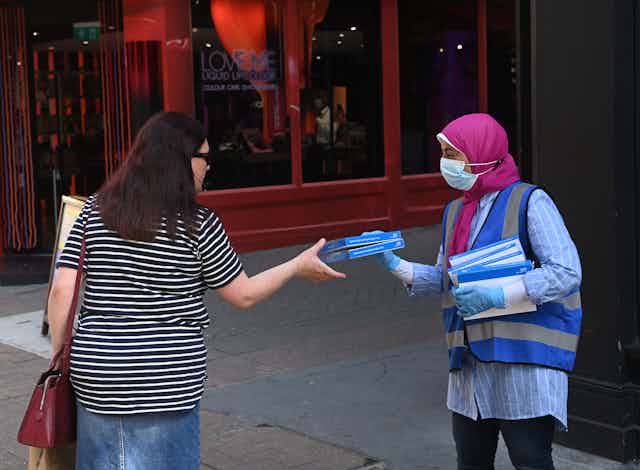 A worker offers free COVID-19 self-test in London.