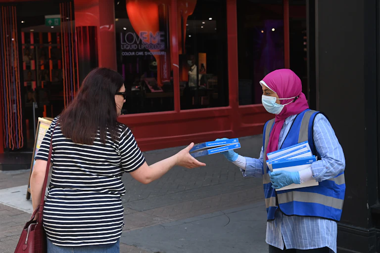 A worker offers free COVID-19 self-test in London.
