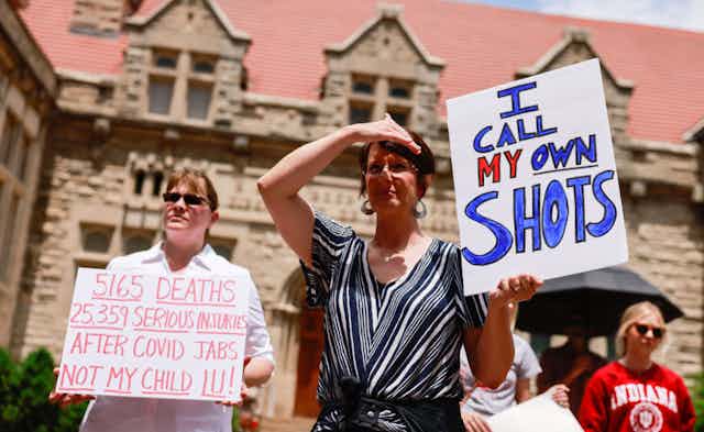 Anti-vaccination protesters hold placards at Indiana University in June 2021rsit