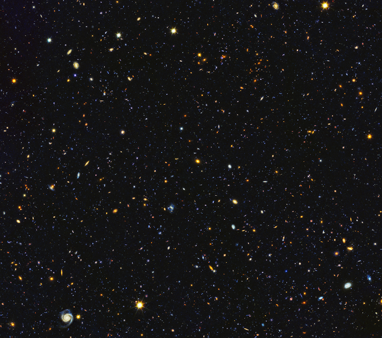 15,000 galaxies appear as small dots and blots in this NASA photograph of the nighttime sky.