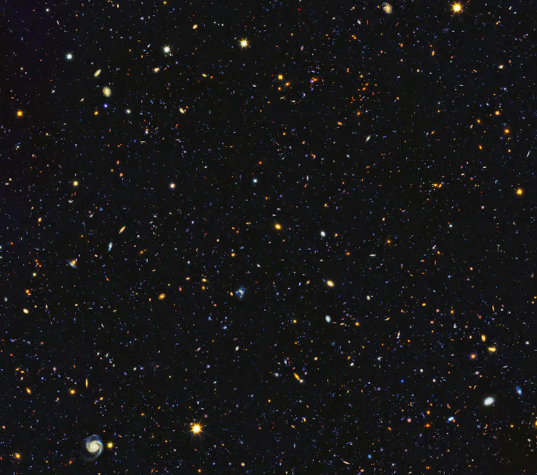 15,000 galaxies appear as small dots and blots in this NASA photograph of the nighttime sky.