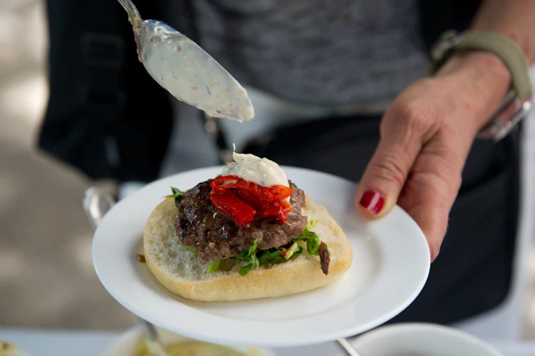 A person puts dressing on an insect burger during a global Pestaurant event in Washington in 2014.
