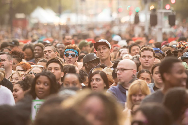 A crowd in a street with varying ages and backgrounds.