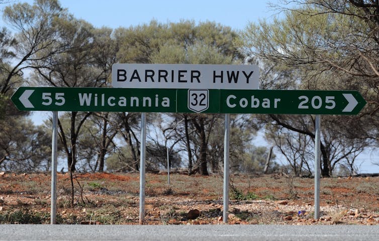 Outback road sign showing Wilcannia 55km away.