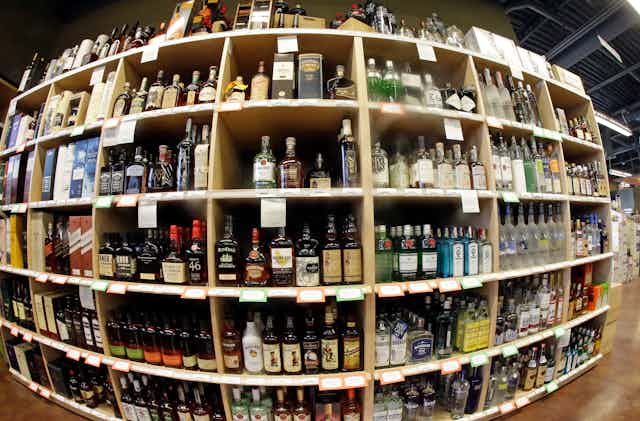 Many shelves of alcoholic beverages in a store.