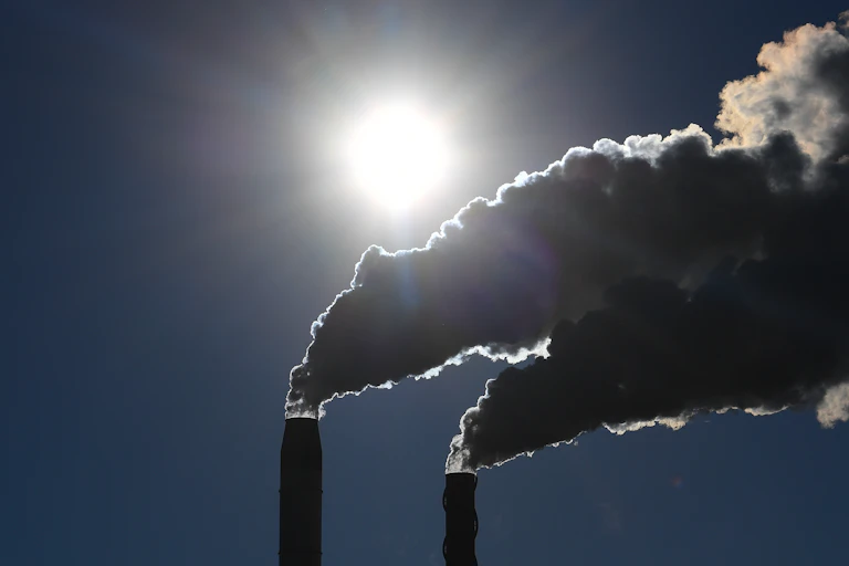 Two plumes of smoke leaving industrial chimneys