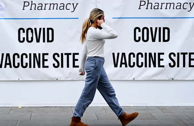 A woman walking past a COVID vaccine centre