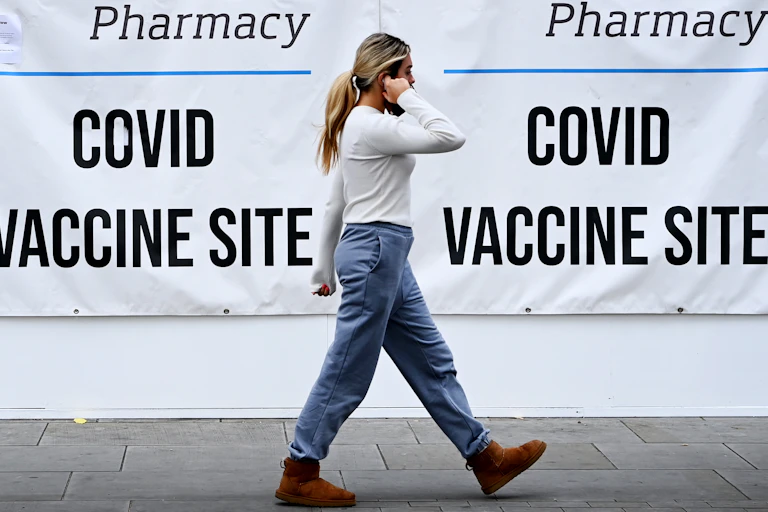 A woman walking past a COVID vaccine centre