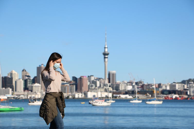 A woman in a mask on the waterfront in Auckland