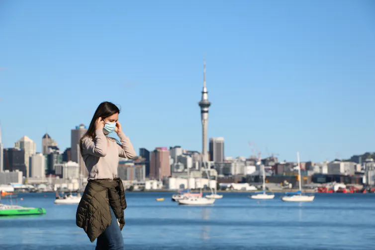 A woman in a mask on the waterfront in Auckland