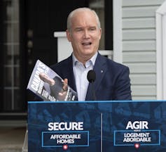 Erin O’Toole holds up his party’s platform book