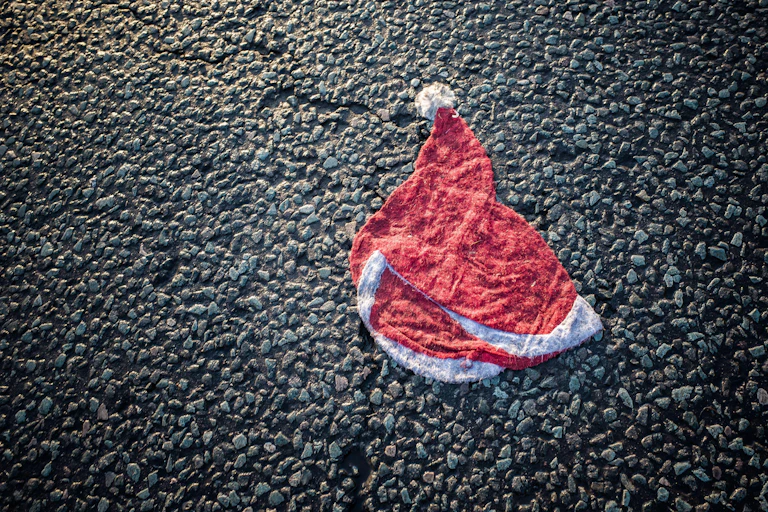 Wet and flattened Santa hat on a road