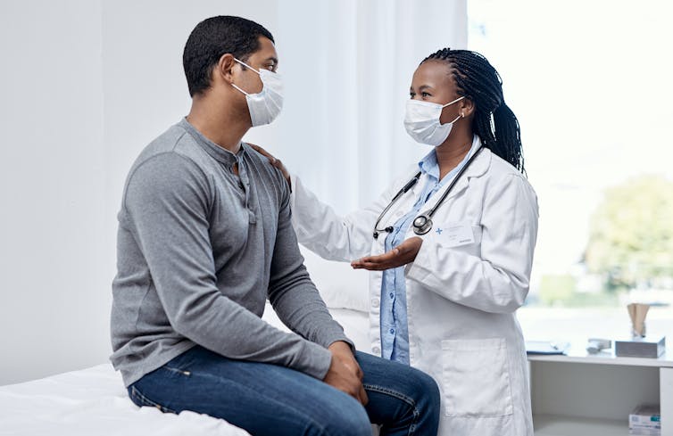 Masked doctor and patient at the doctors' office