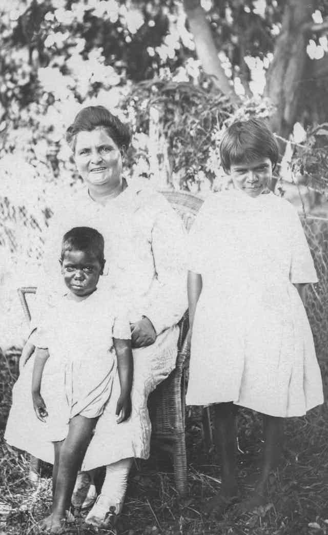 A white woman with two young Aboriginal children