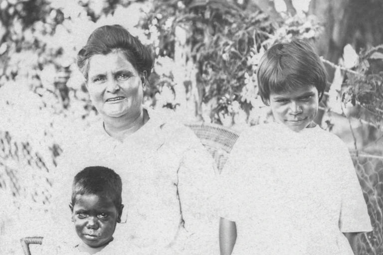 A white woman with two young Aboriginal children