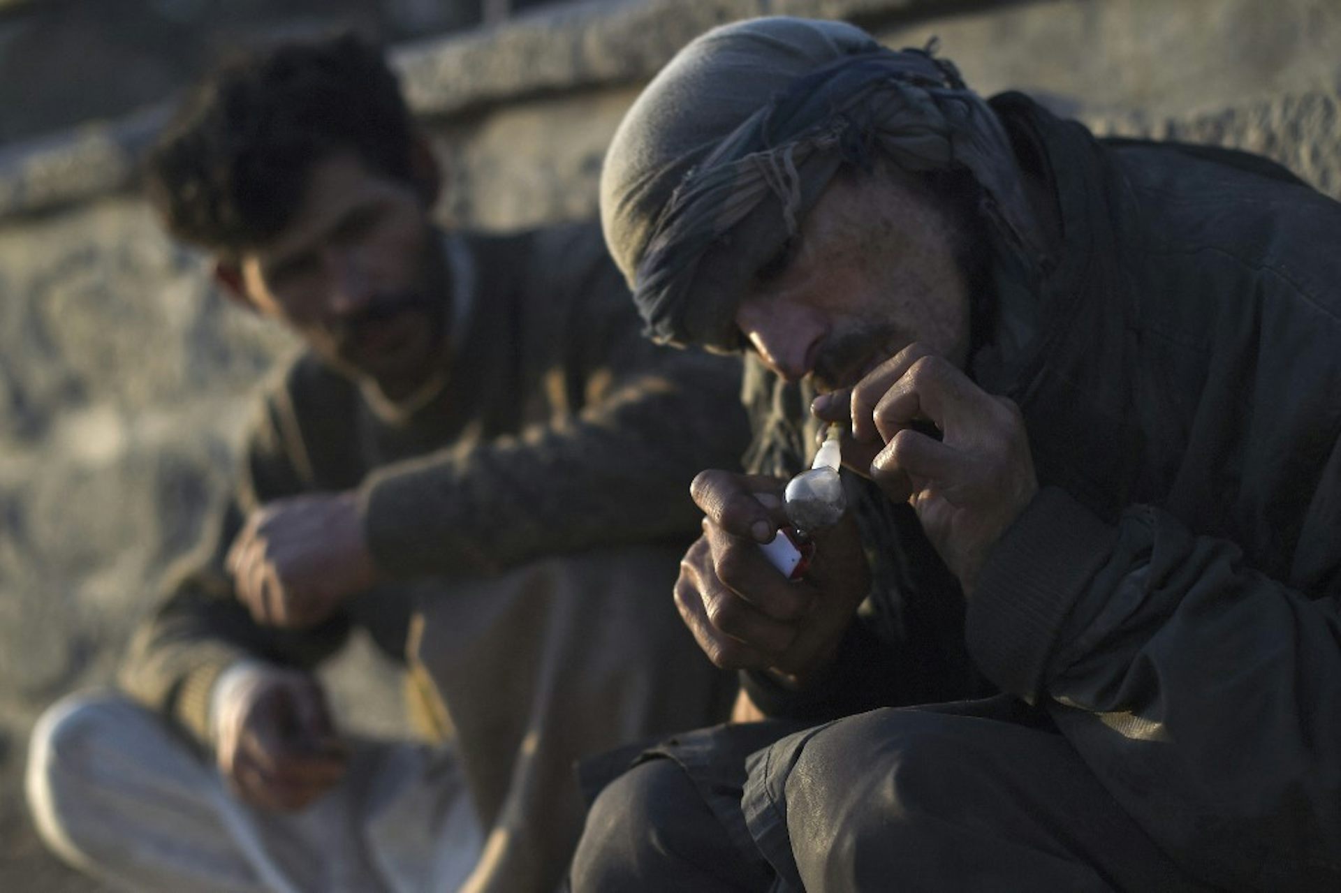 Un homme en turban fume de l'opium dans une pipe