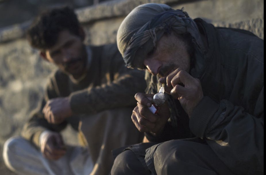 Un homme en turban fume de l'opium dans une pipe